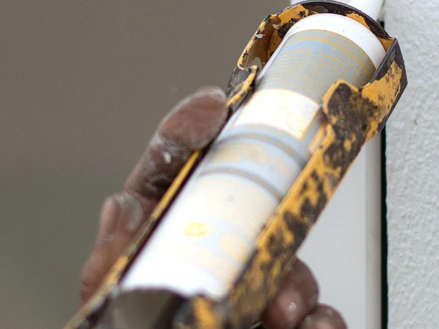 Applying caulk during home maintenance