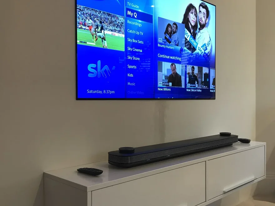 Wall-mounted flat-screen TV with soundbar
